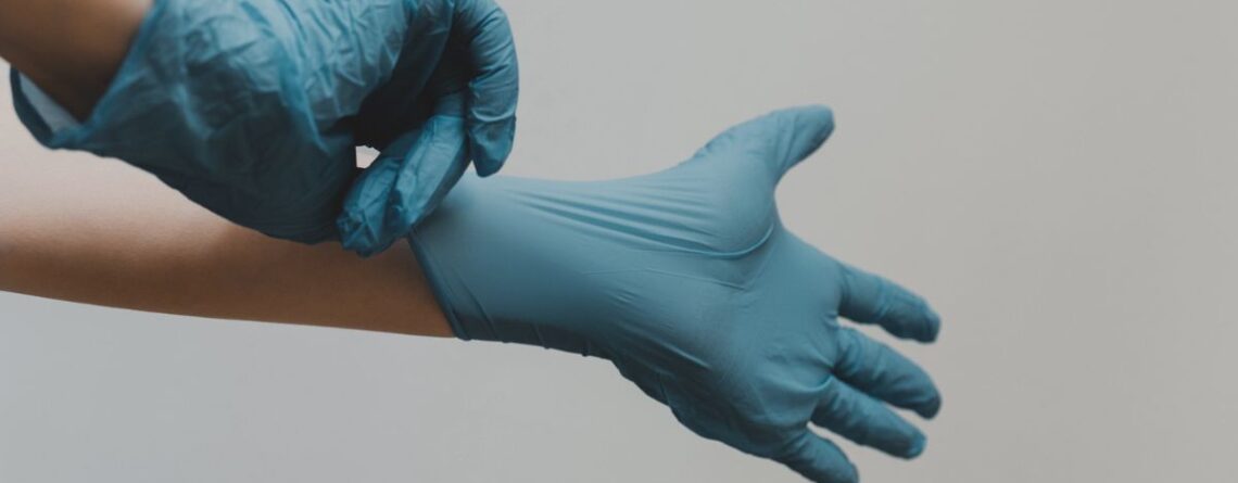 Biohazard cleaner preparing by putting on safety gloves